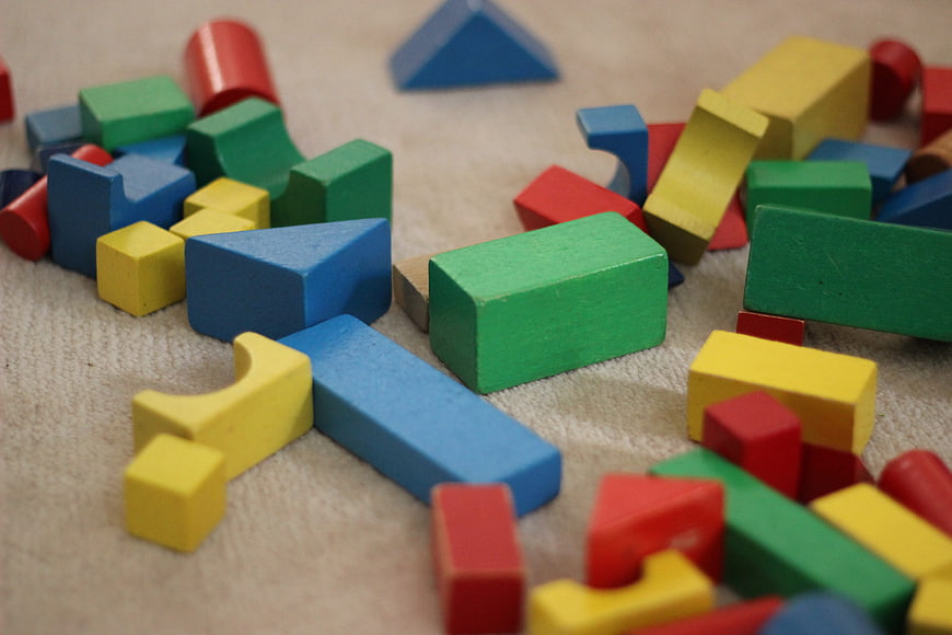 Colorful Wooden Building Blocks Scattered on Carpet
