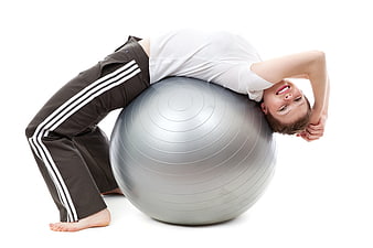 Woman stretching on silver exercise ball isolated on white