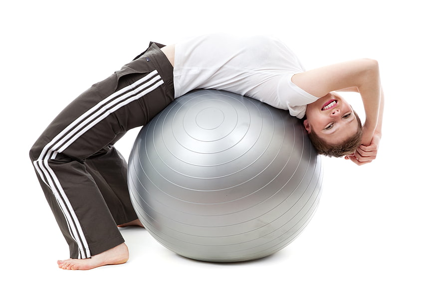 Woman stretching on silver exercise ball isolated on white