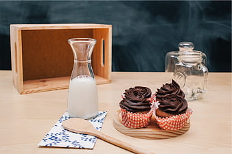 Chocolate Cupcakes with Milk and Wooden Spoon on Table