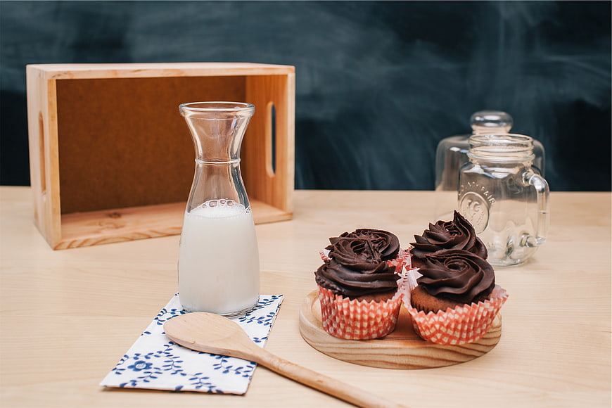 Chocolate Cupcakes with Milk and Wooden Spoon on Table