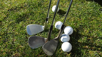 Golf Clubs And Balls On Green Grass