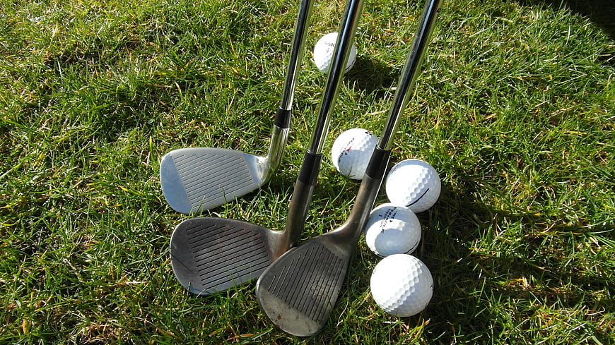 Golf Clubs And Balls On Green Grass