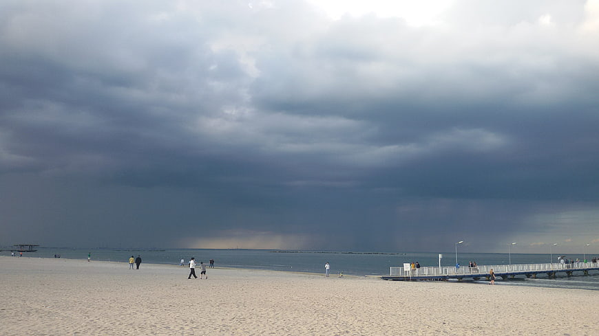 Dramatic Storm Clouds Over Beach with People Walking