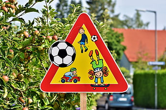 Children Playing Warning Sign With Soccer Ball In Apple Orchard