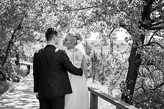 Bride and Groom Embracing on Wooden Bridge in Black and White