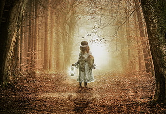 Mystical girl with wings holding lantern in enchanted autumn forest