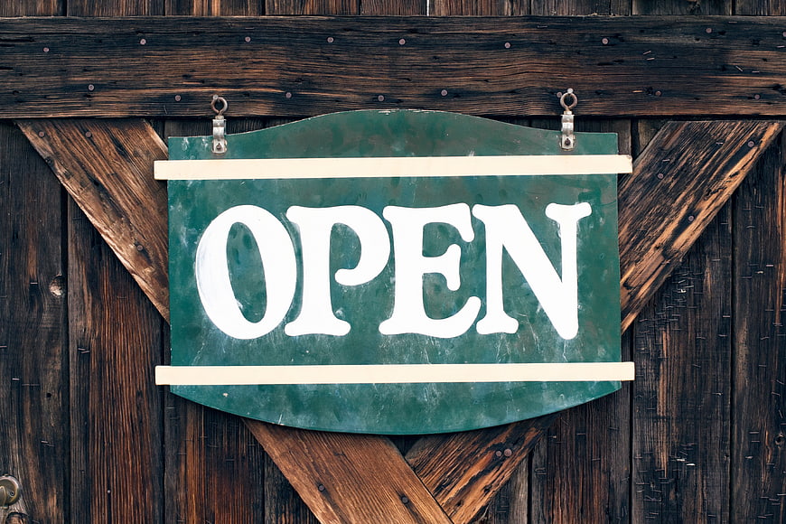 Vintage Green Open Sign on Rustic Wooden Barn Door