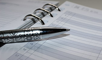 Silver ornate pen on spiral planner calendar page