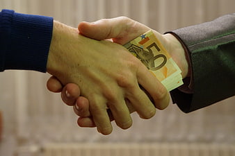 Handshake with hidden fifty euro banknotes