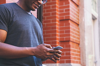 African American Man Texting on Smartphone Outdoors