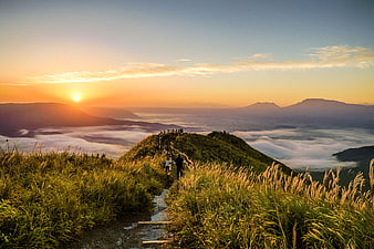 Hikers on Mountain Trail at Sunset Above Sea of Clouds