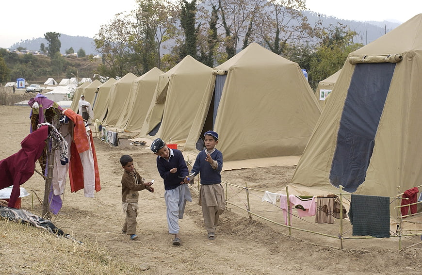 Children playing in a refugee camp with tents