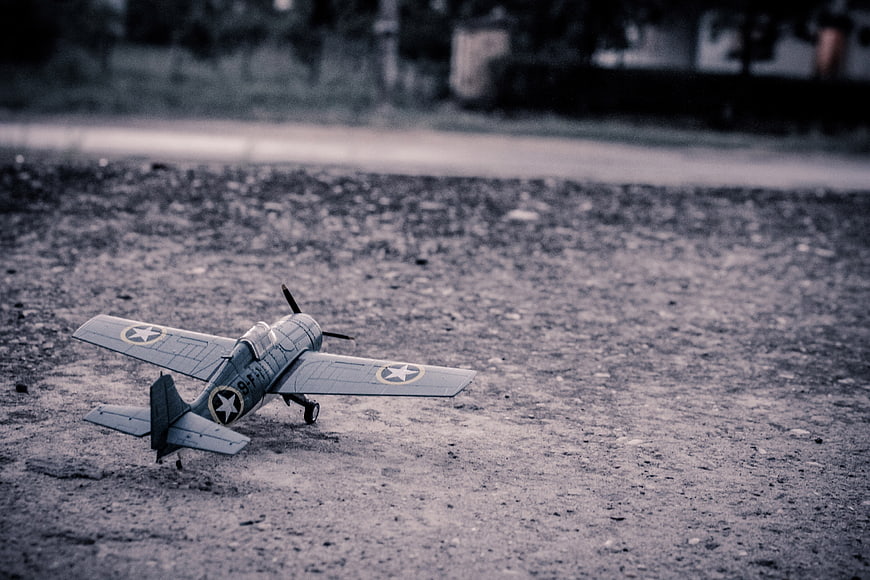 Vintage Gray Model Airplane on Gravel Ground