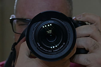 Close-up of photographer holding camera lens