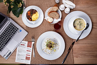 Overhead view of business lunch with laptop and menu