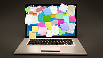 Laptop with colorful sticky notes bursting from screen