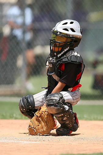 Young Baseball Catcher in Full Gear Crouching on Field