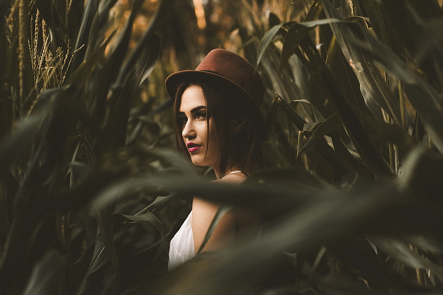Woman in Fedora Hat Standing in Cornfield