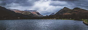 Dramatic Snow-Capped Mountains Over Lake Under Cloudy Sky