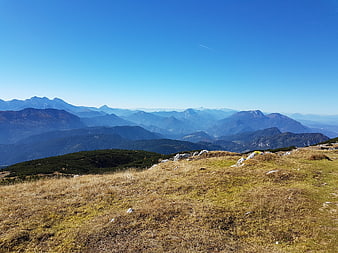 Panoramic mountain landscape with grassy foreground and blue sky