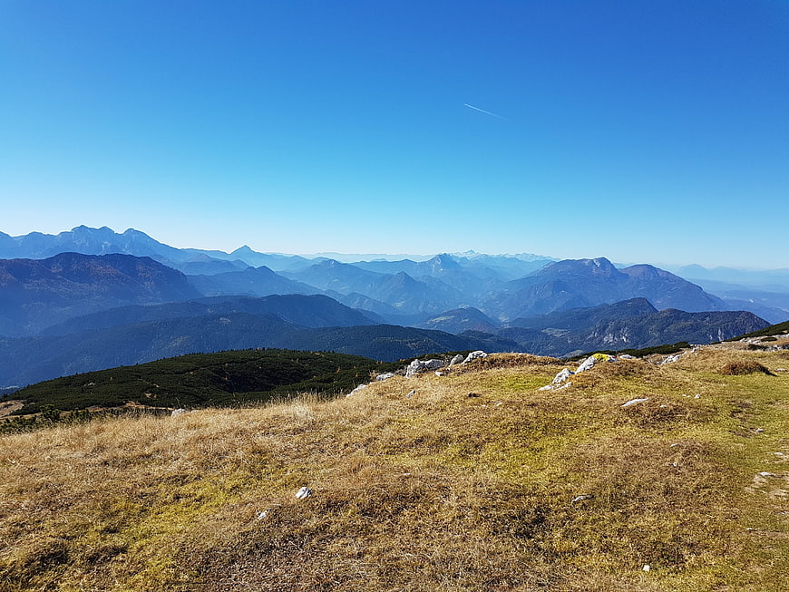 Panoramic mountain landscape with grassy foreground and blue sky
