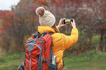 Woman Hiker Taking Photo of Autumn Forest with Smartphone