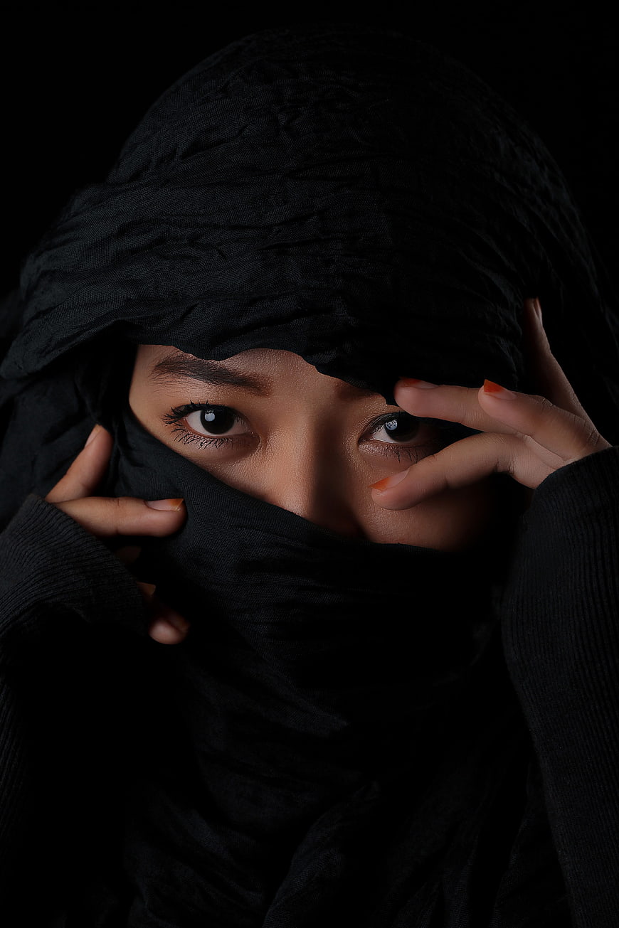 Close-up portrait of woman in black niqab with intense eyes