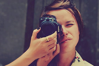 Woman holding vintage Nikon camera to eye