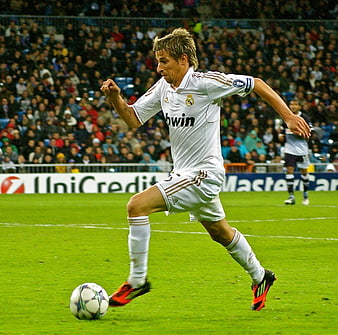 Soccer player dribbling ball on green pitch