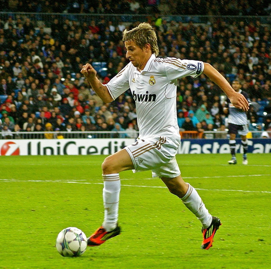 Soccer player dribbling ball on green pitch