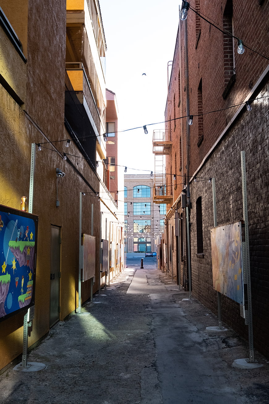 Urban alleyway with brick buildings and string lights