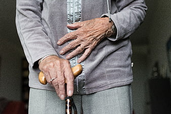 Close-up of elderly woman's hands holding walking stick