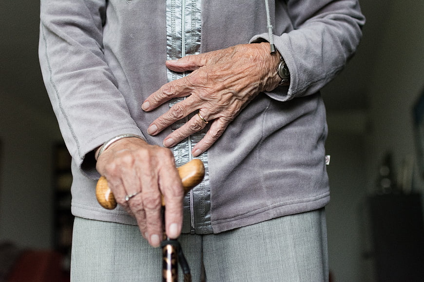Close-up of elderly woman's hands holding walking stick