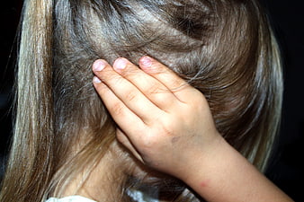 Child scratching head in distress or pain
