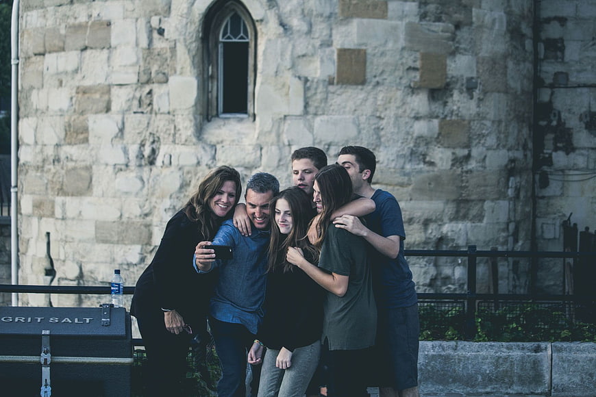 Group of friends taking a selfie in front of a stone building