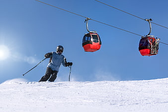 Skier on Slope with Red Gondola Lifts