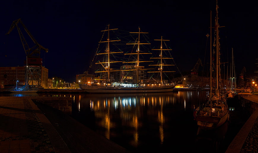 Illuminated Tall Ship Moored in Harbor at Night