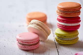 Colorful French Macarons Stacked on White Wooden Table