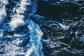 Aerial View of Turbulent Blue Ocean Waves and White Sea Foam