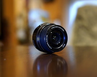 Black Sony Camera Lens on Wooden Table