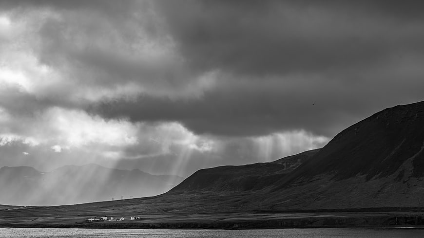 Dramatic Black and White Landscape with Sun Rays Over Mountains