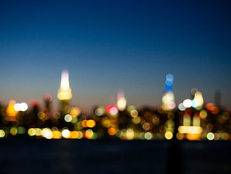 Blurred Bokeh City Skyline at Night with Blue Sky