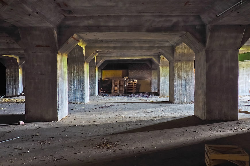 Abandoned Concrete Warehouse Interior With Pillars And Decay
