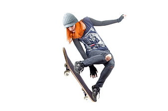 Young woman with orange hair skateboarding on white background
