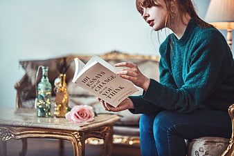 Woman reading 101 Essays book in elegant vintage living room