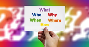 Hand holding card with question words against colorful background