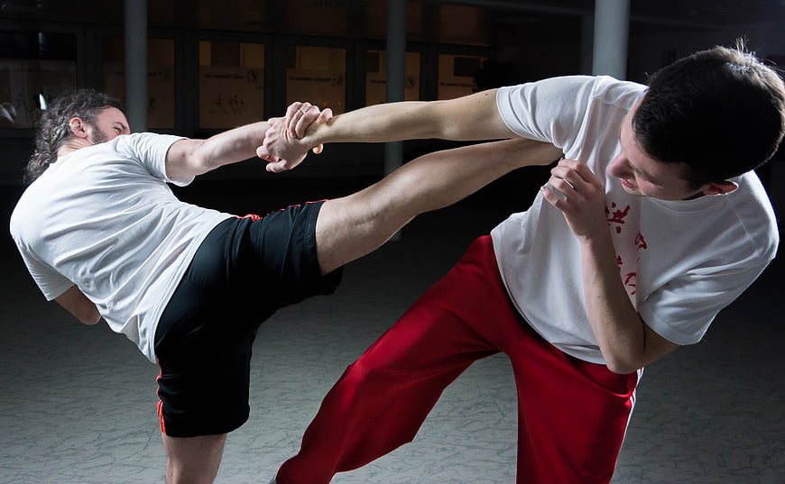 Two Men Practicing Martial Arts Kick and Block