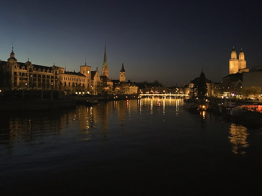 Night cityscape of Regensburg skyline with illuminated church spires and river reflections