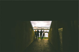 Silhouetted Group Standing in Stadium Tunnel Looking at Field